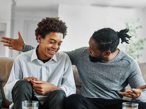 LGBTQ coming-out moment between a black father and son sitting on their living room couch