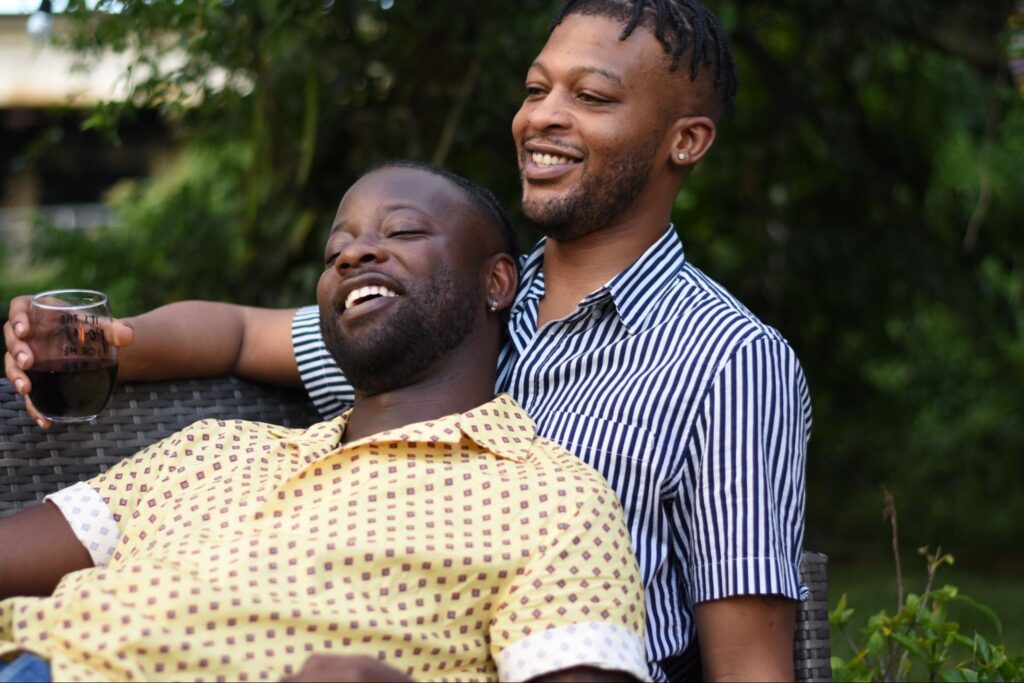 Young supportive gay Black couple smiling and relaxing outdoors